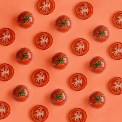 Cherry tomatoes, some whole, some sliced in half, arranged in diagonal stripes.